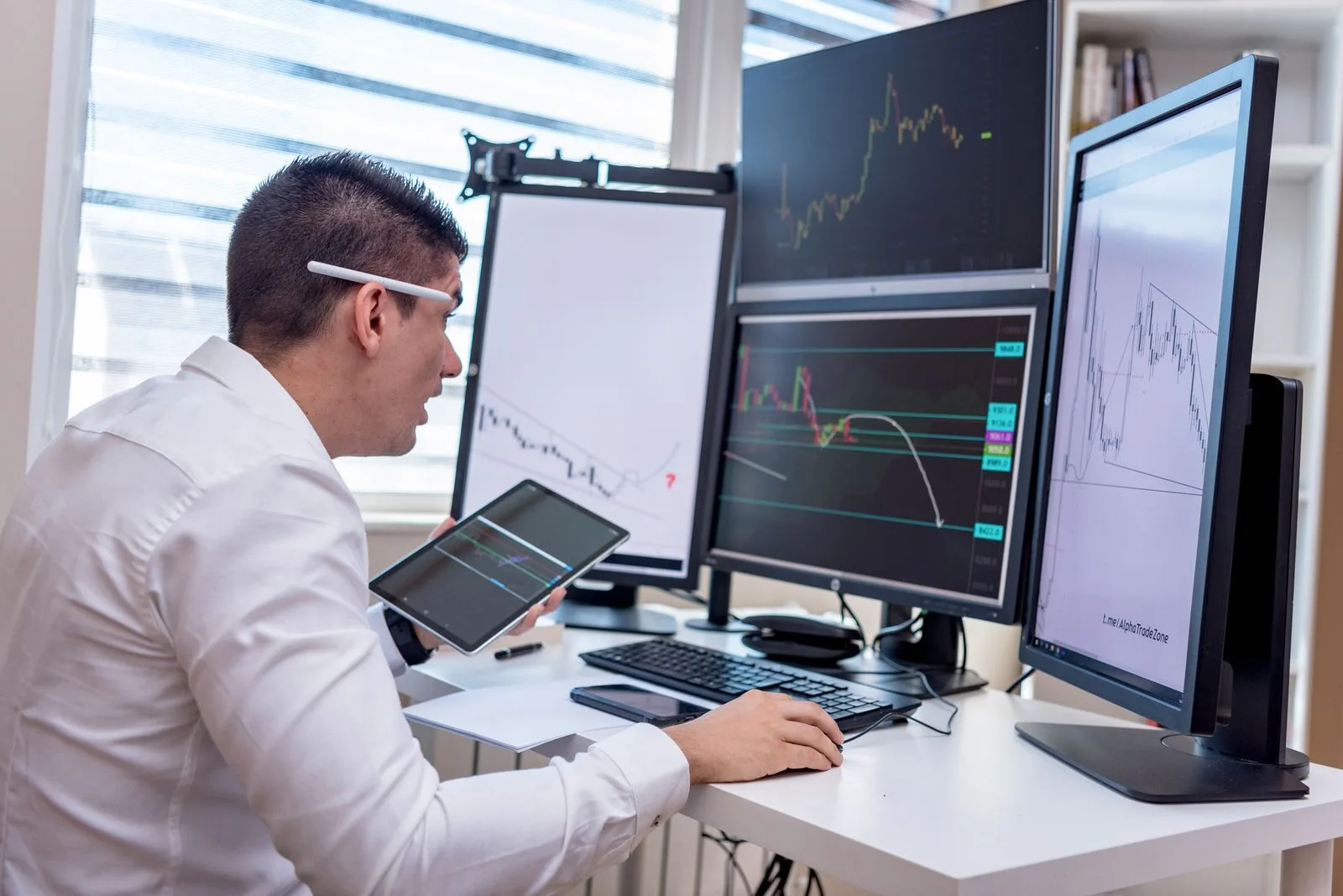 A business owner monitoring operations across multiple screens from one control panel