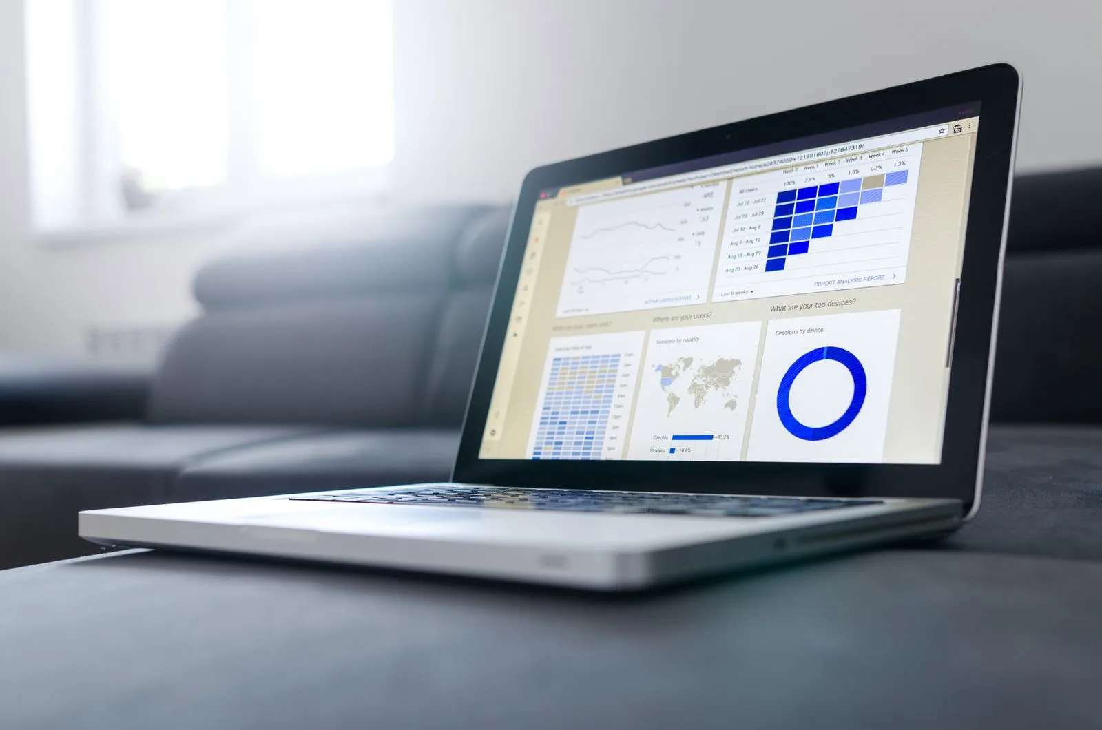 Laptop screen displaying data analytics and monitoring graphs in a bright office