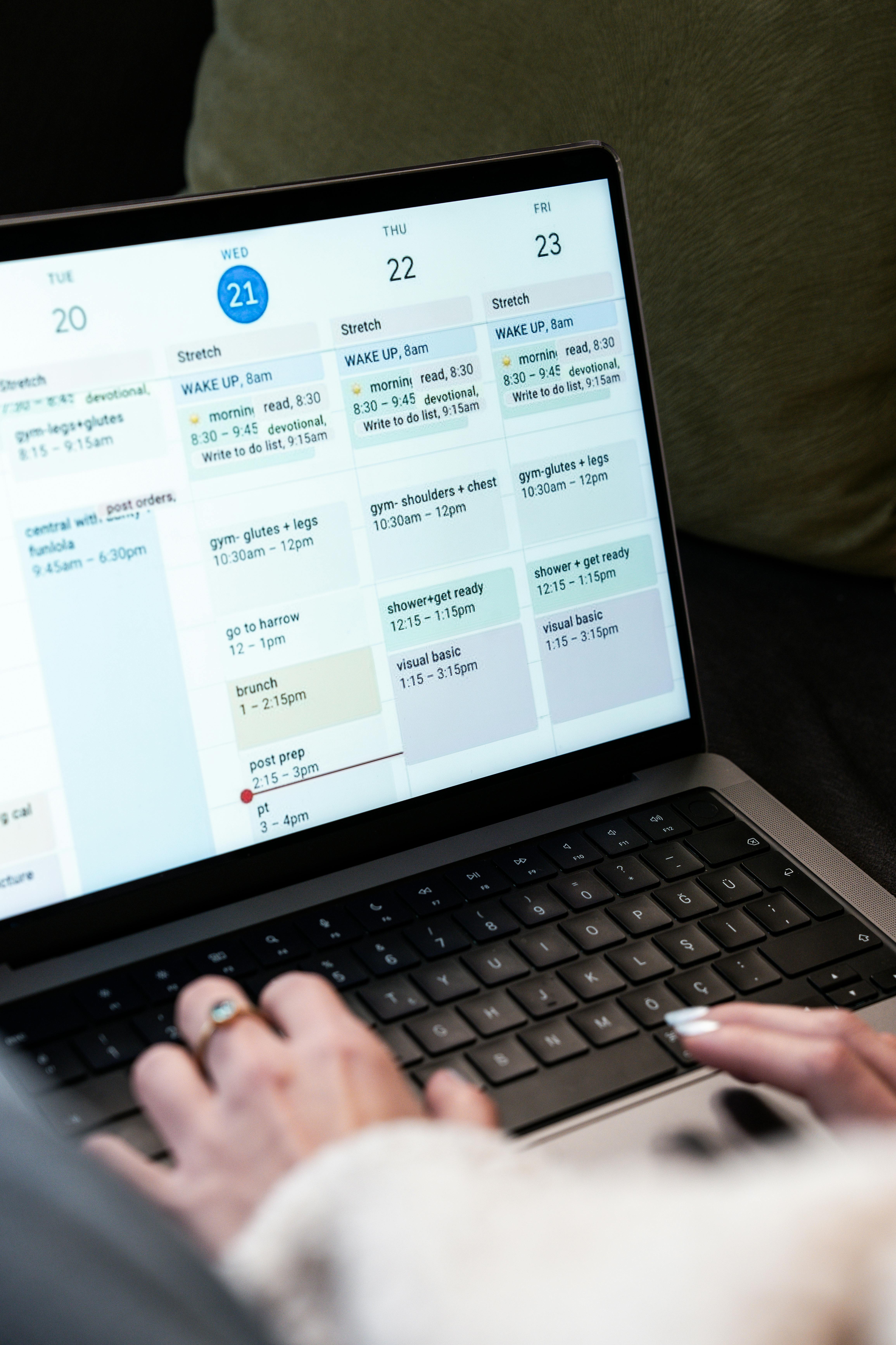 Woman using a laptop to manage her weekly schedule with a digital calendar, representing automated online booking systems for service businesses