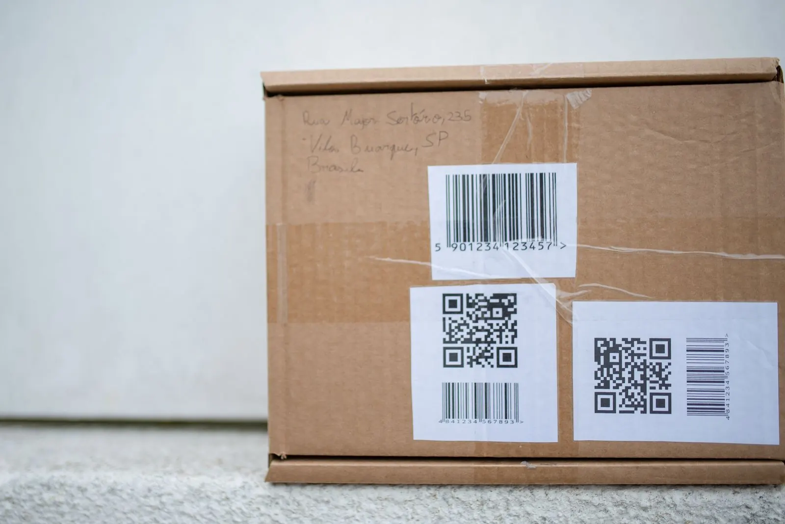 A cardboard box with barcode and QR code labels
