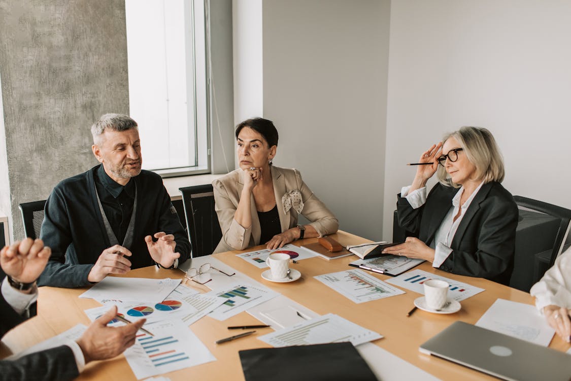Diverse group of business professionals in a strategic meeting discussing documents and charts
