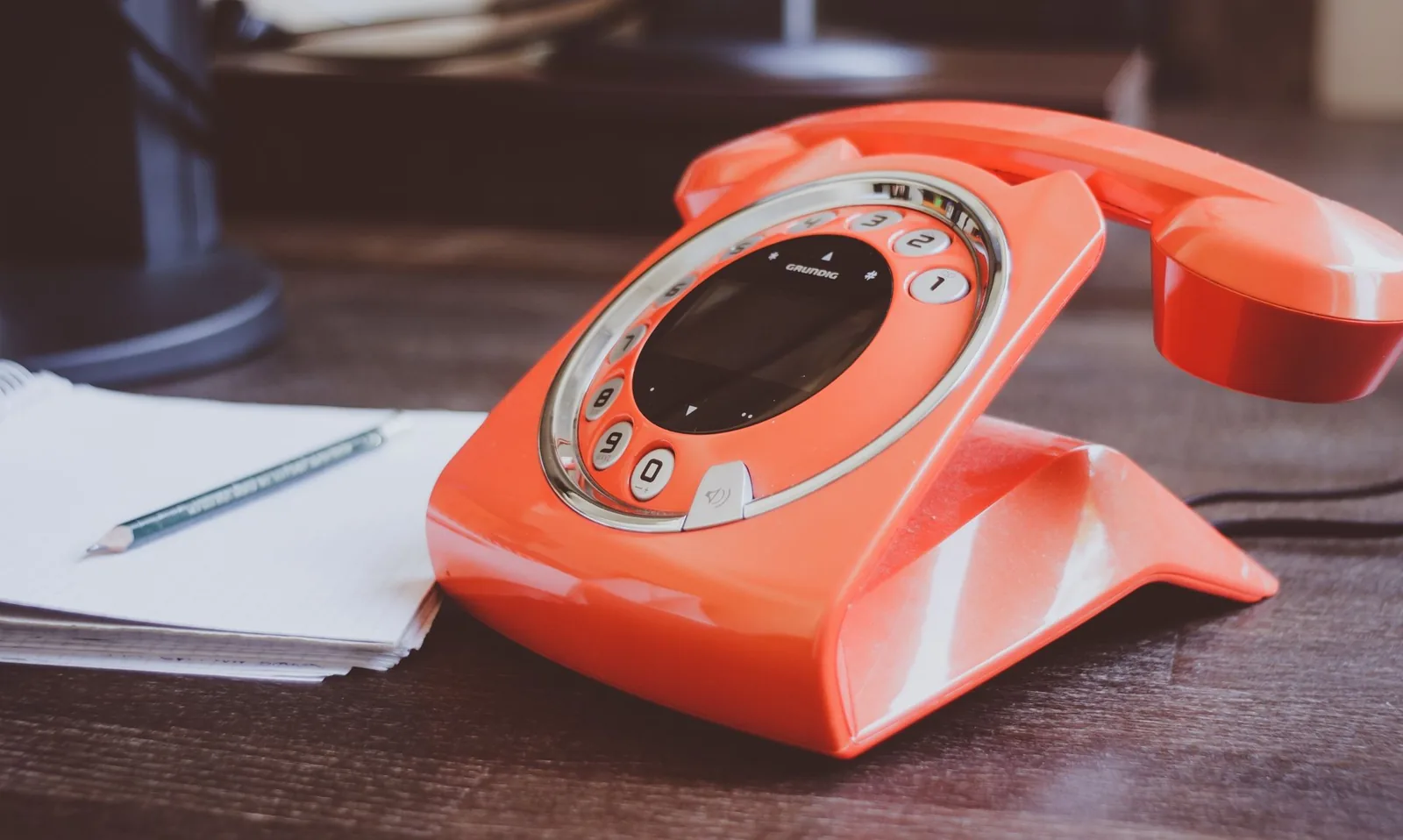 A warehouse phone handset next to a handwritten order form being filled in