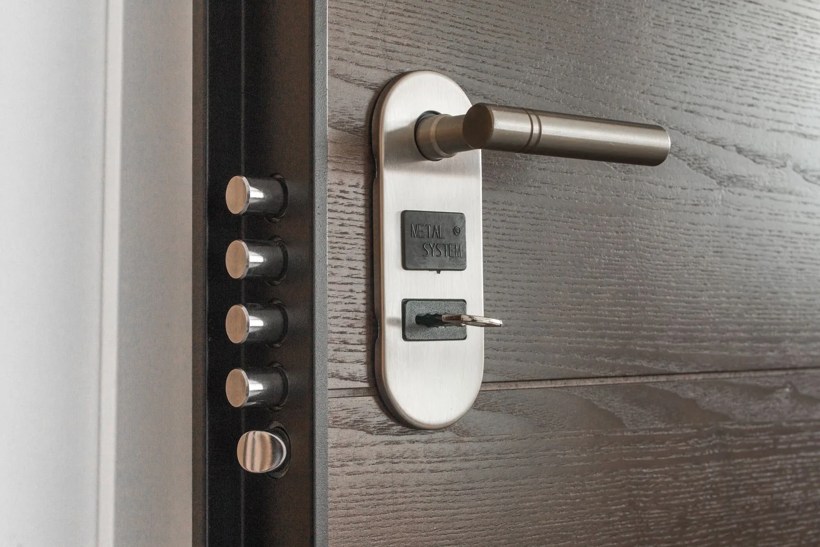 A metal door handle and lock system with a key inserted