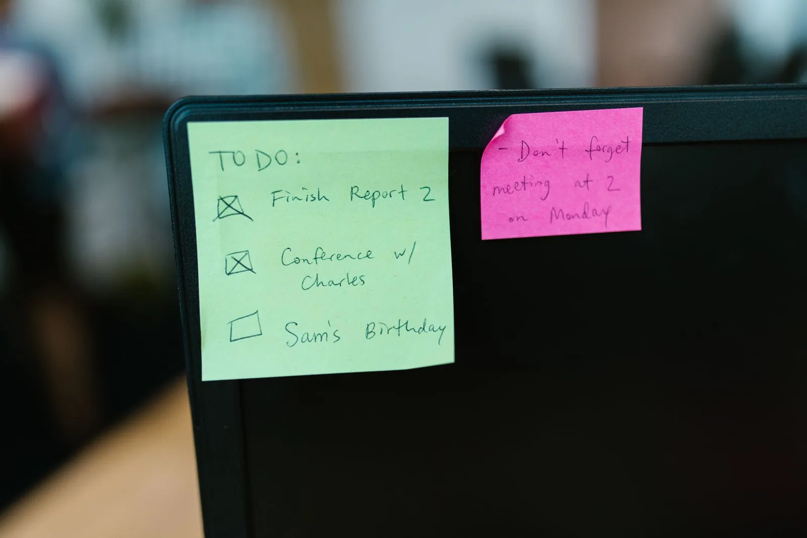 Colorful sticky notes with reminders covering an office computer monitor