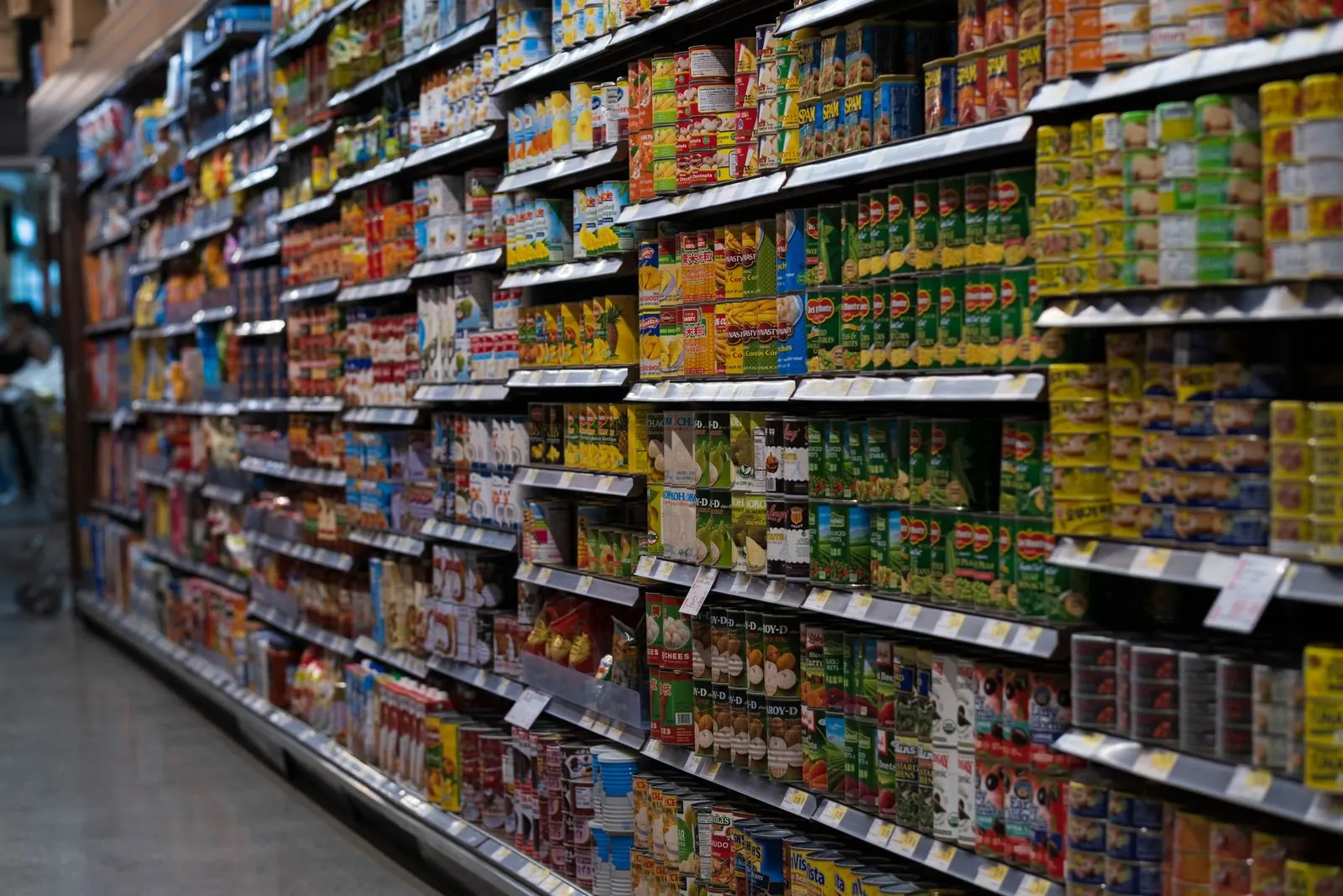 A supermarket aisle with shelves of packaged and canned goods