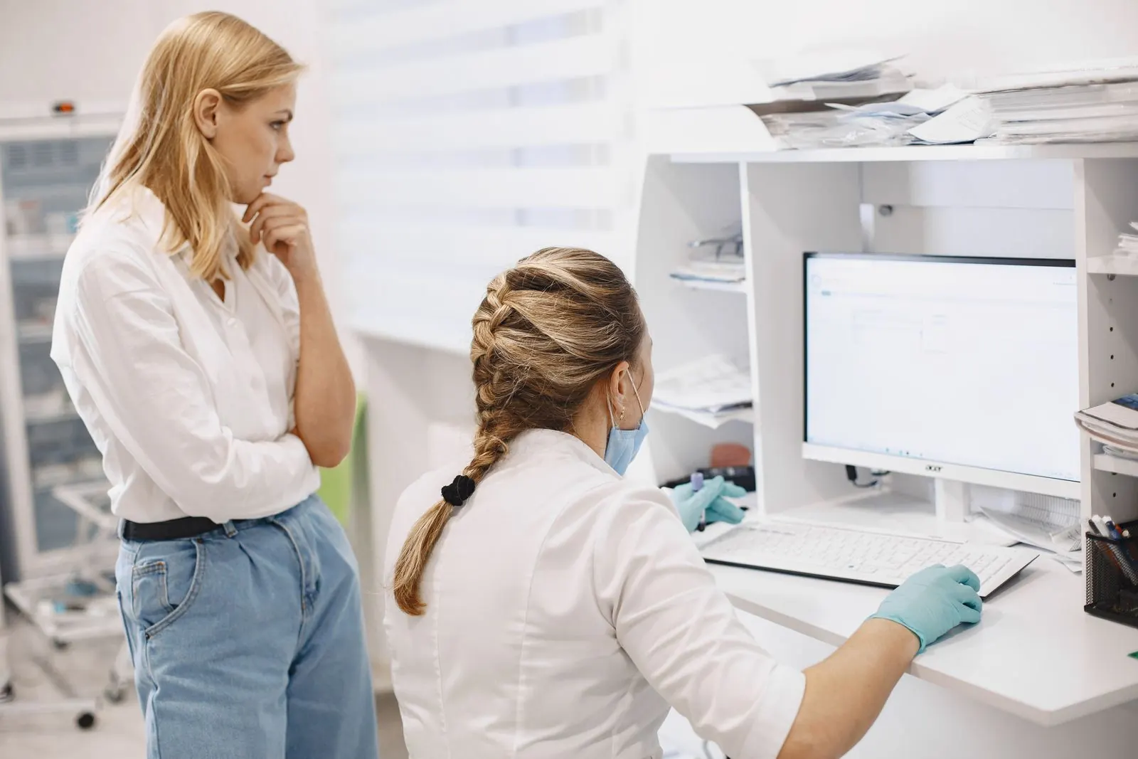 Two clinic staff members at a computer in a medical office