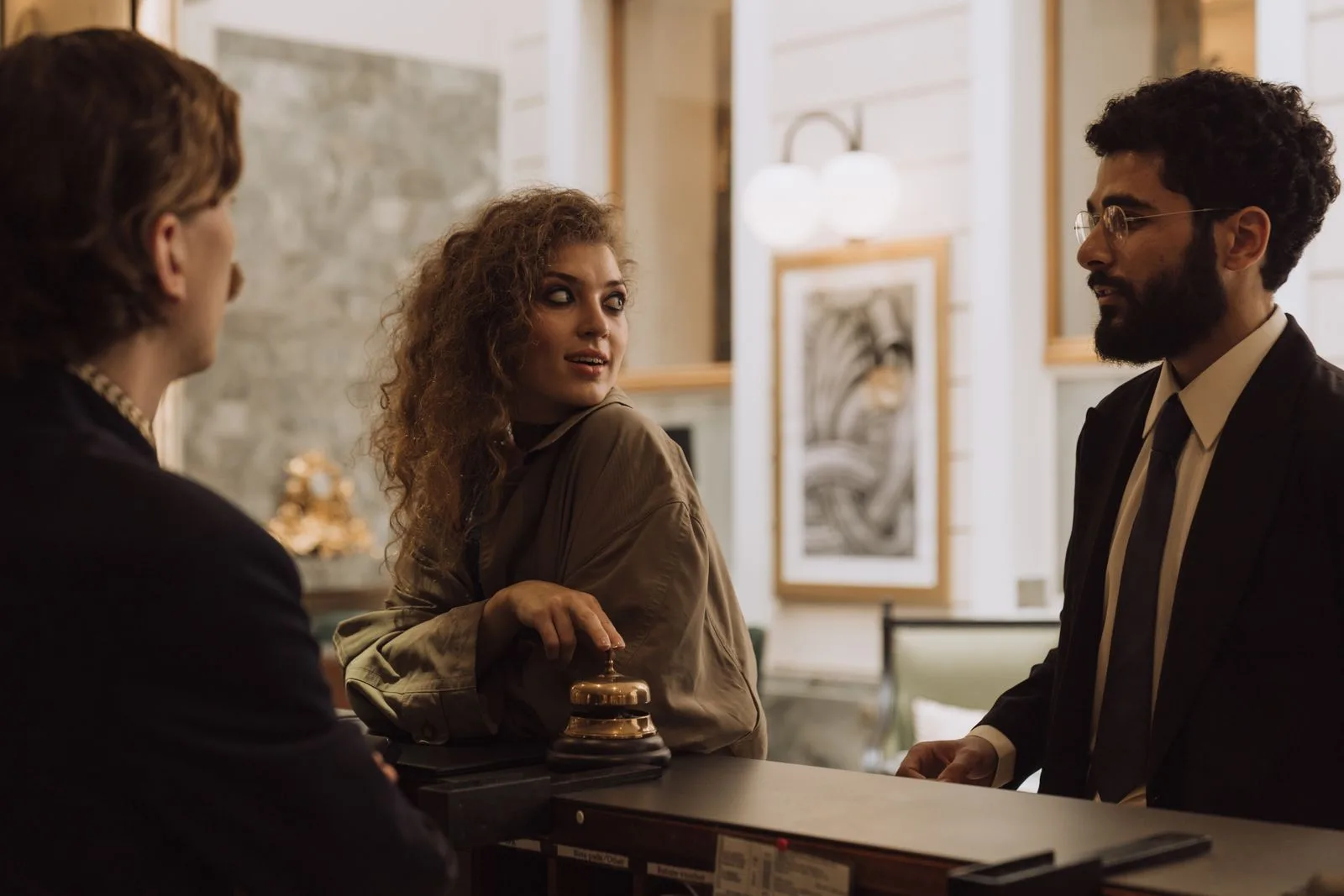 Guests interacting with staff at a hotel reception desk during check-in