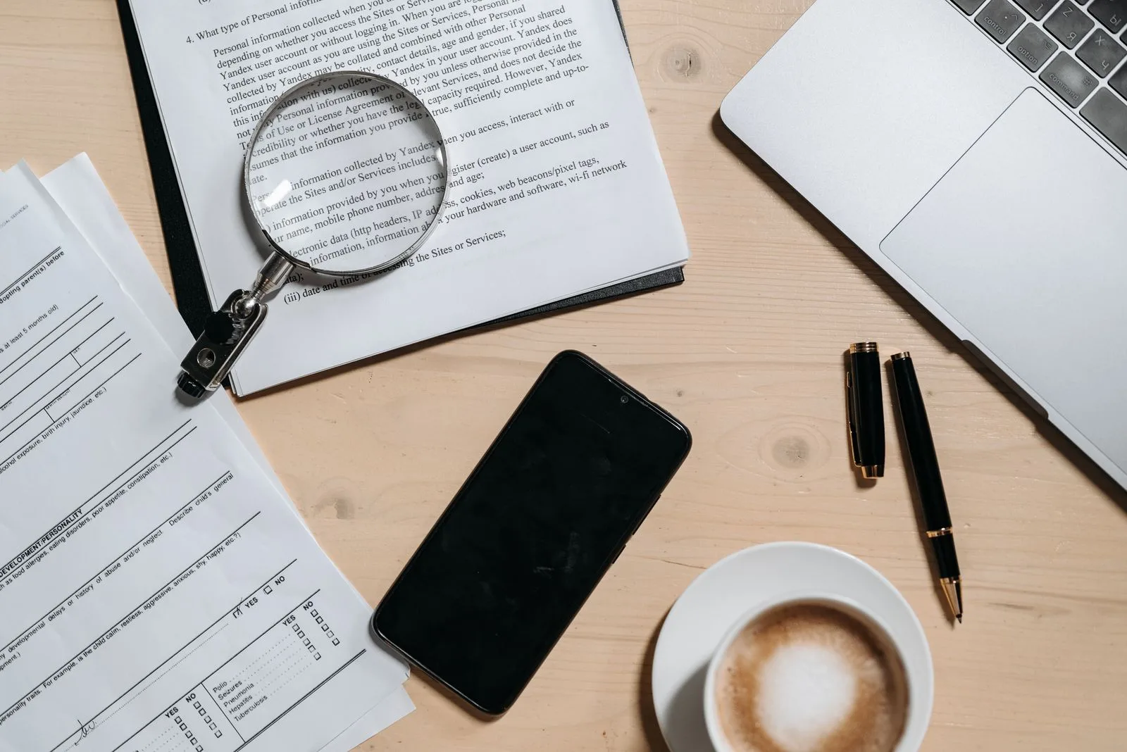 A magnifying glass over business documents on a desk, representing reviewing a software proposal