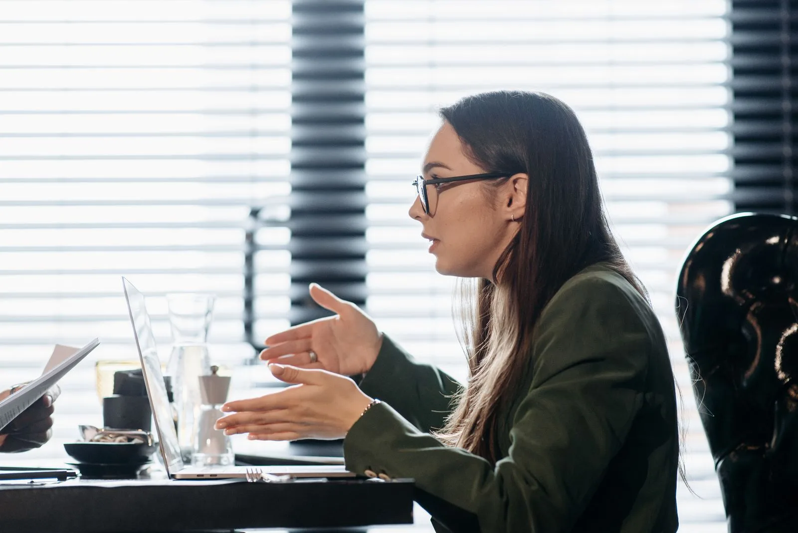 A businesswoman gesturing while explaining something clearly during a meeting