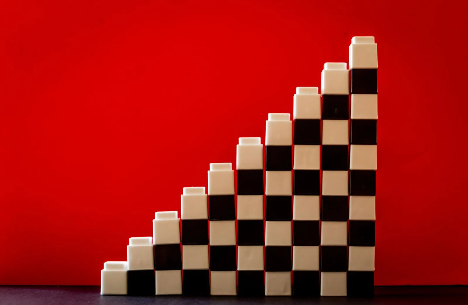 Colorful checkered building blocks arranged in a stair formation, representing modular construction