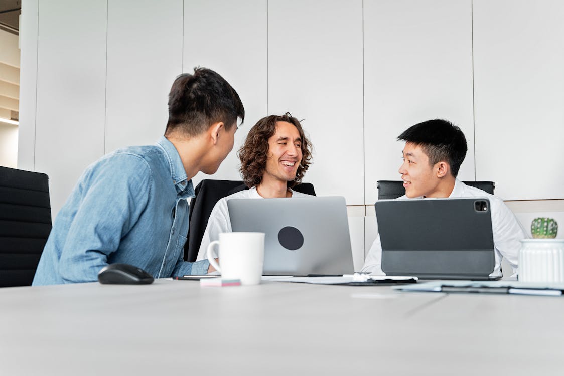 Diverse colleagues collaborating in a modern office with laptops and tablets — hybrid work in financial services