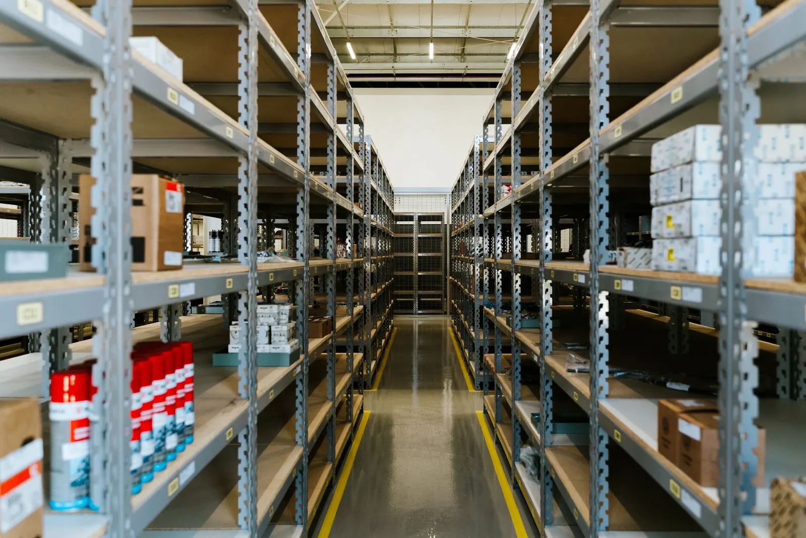 A long aisle between metal storage shelves in a stockroom