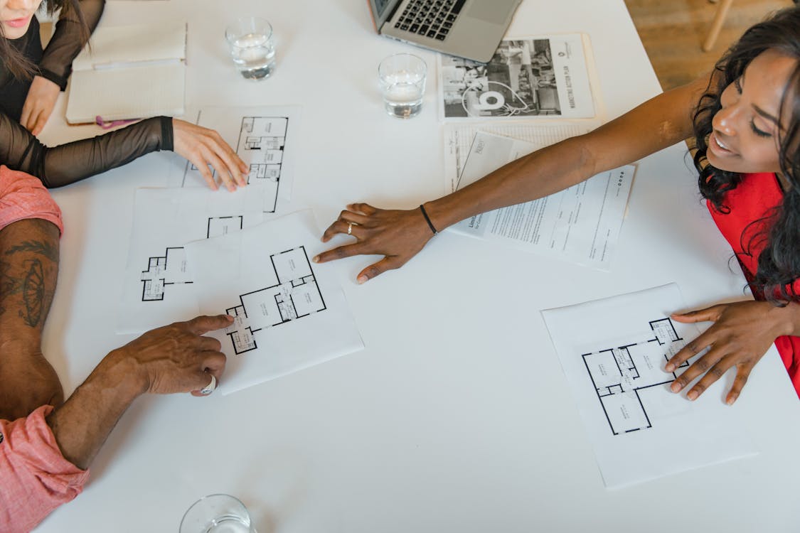 Diverse business team reviewing project plans around a table — Photo by RDNE Stock project on Pexels