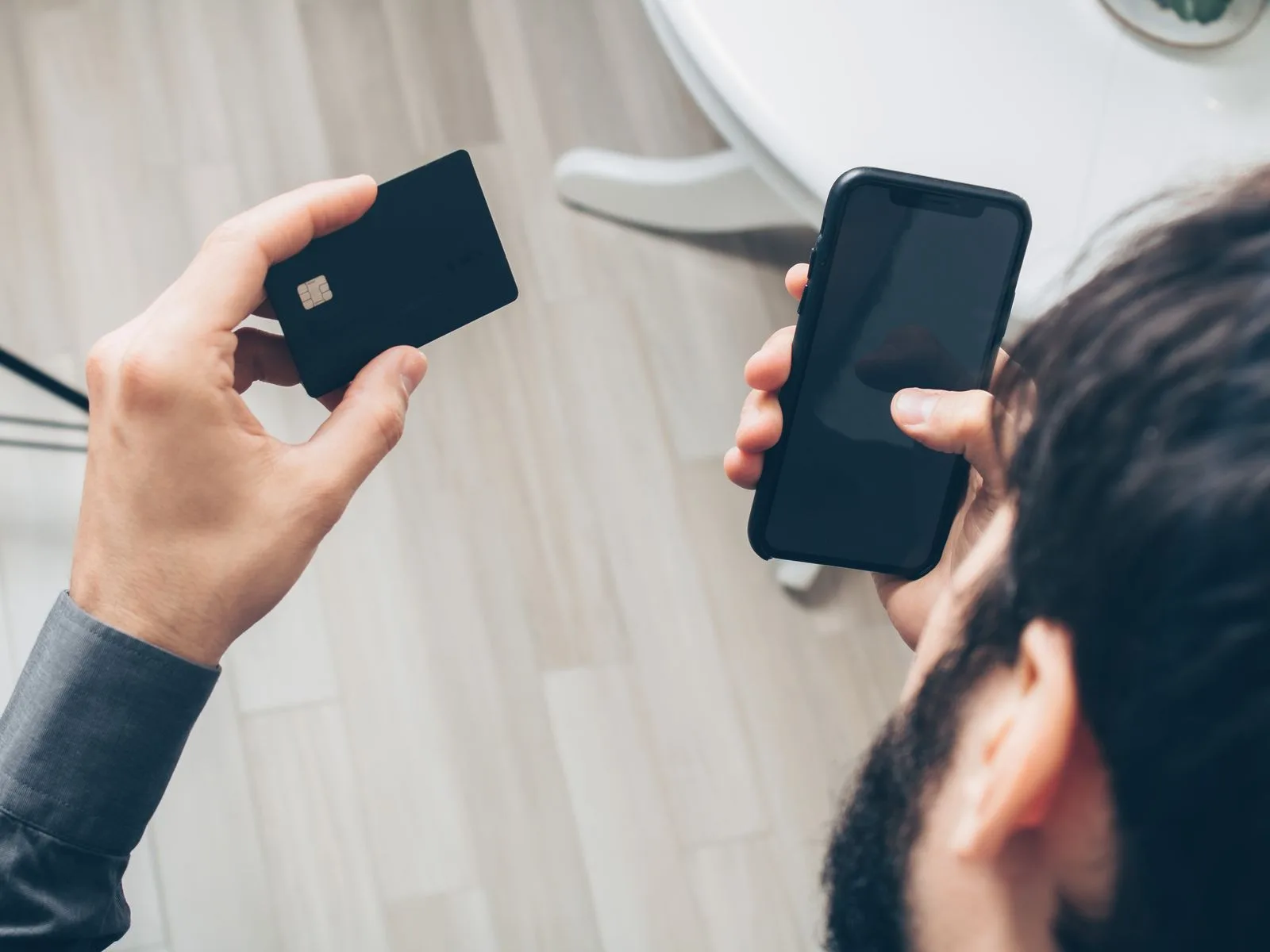 A person holding a smartphone and credit card while making an online payment