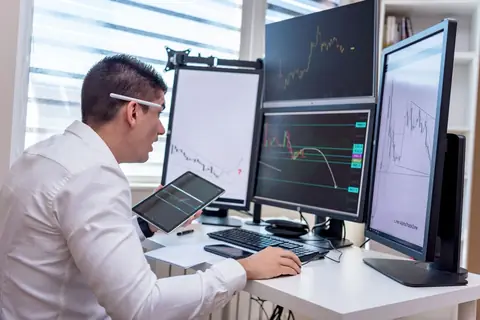 A business owner monitoring operations across multiple screens from one control panel