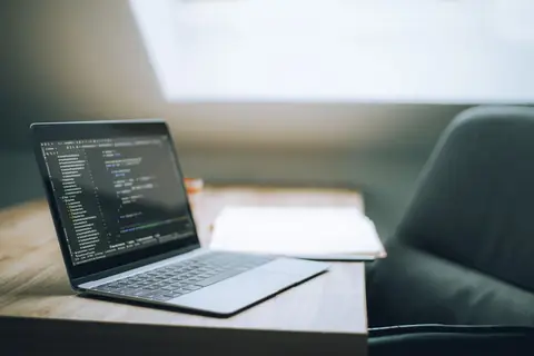 A modern workspace with a laptop displaying lines of code