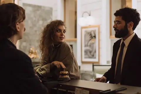 Guests interacting with staff at a hotel reception desk during check-in