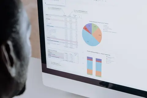 A spreadsheet open next to a business management software dashboard on the same screen