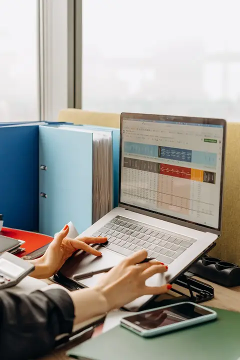 A spreadsheet full of formulas next to a web application dashboard showing the same totals