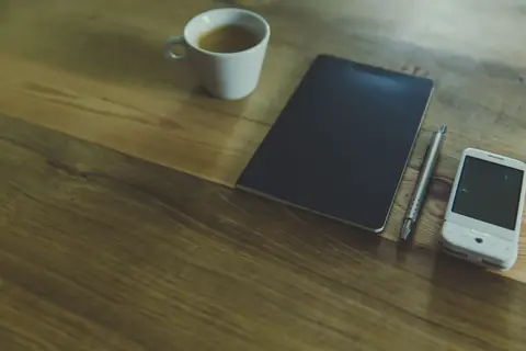 An empty desk with a notebook and sticky notes left behind after an employee's last day
