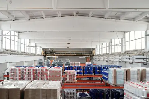 A spacious warehouse interior with organized shelves and stacked pallets
