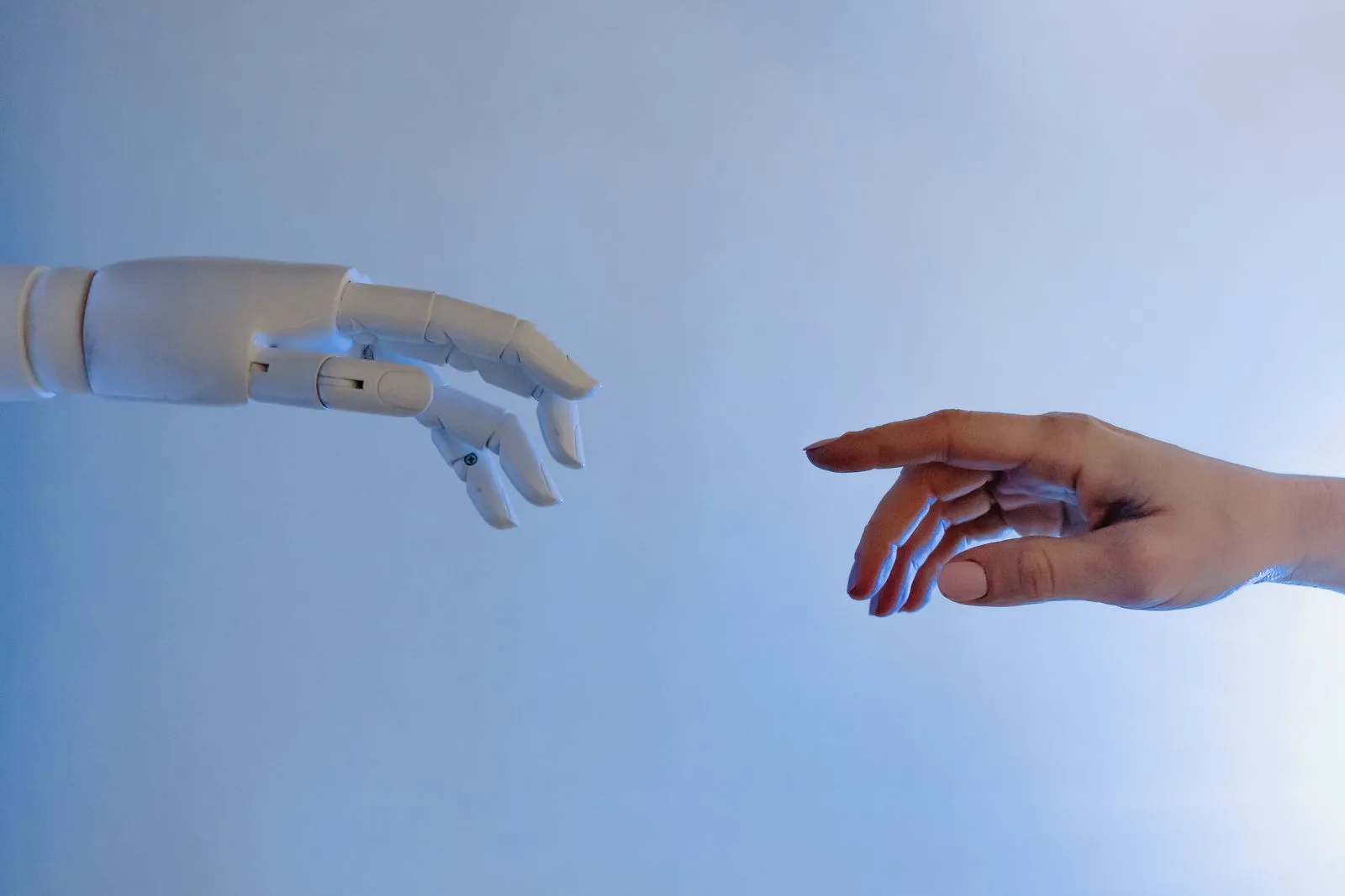 A human hand reaching toward a robotic hand, symbolizing technology and collaboration