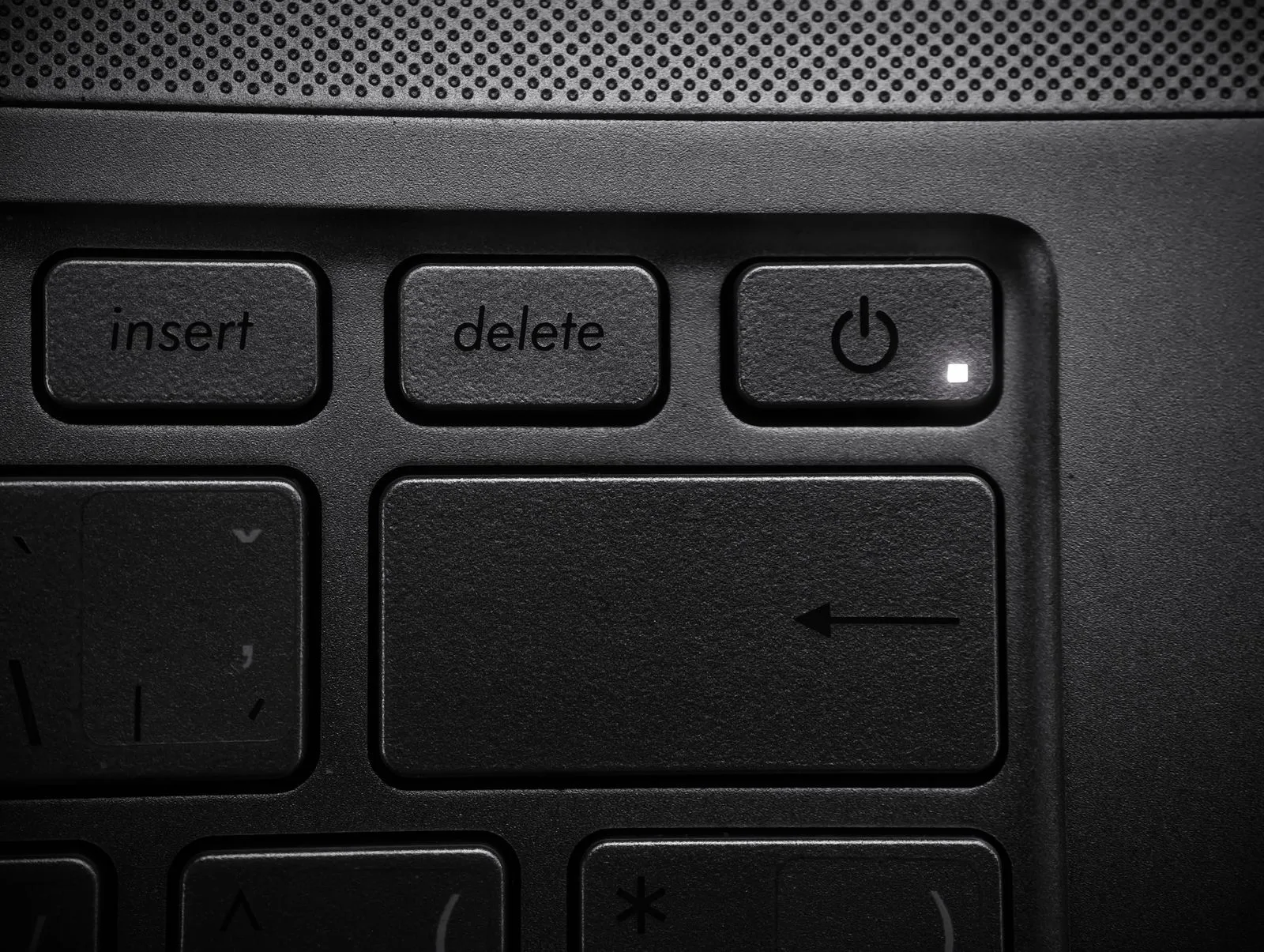 Close-up of a laptop keyboard highlighting the power and delete keys