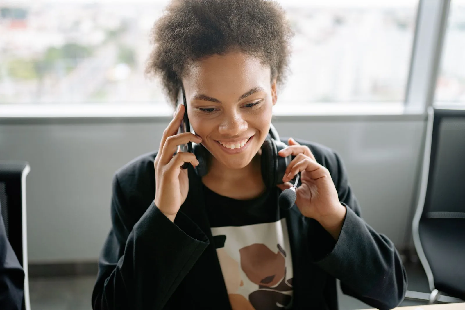 A cheerful call center agent talking on the phone while wearing a headset