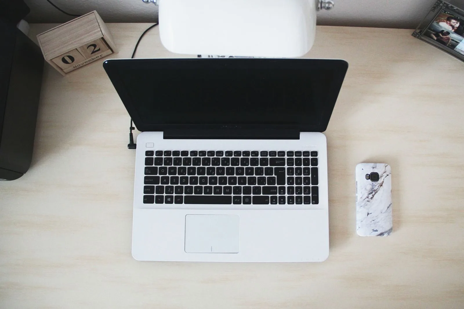 A minimalist, organized workspace with a laptop and desk accessories neatly arranged