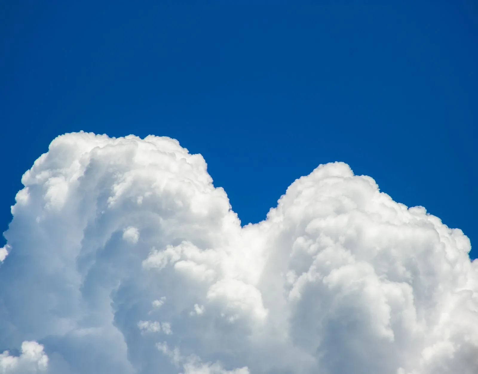 Fluffy white clouds floating in a bright blue sky
