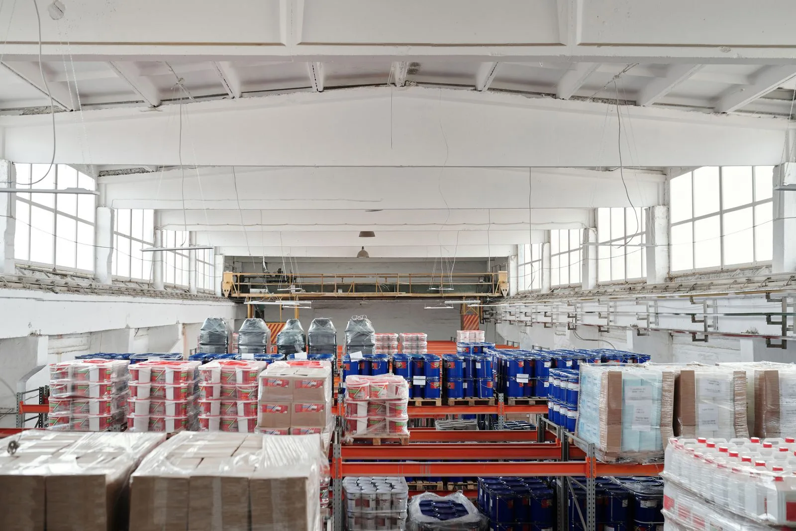 A spacious warehouse interior with organized shelves and stacked pallets